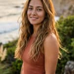 Young woman with beach waves hairstyle at the coast during sunset.